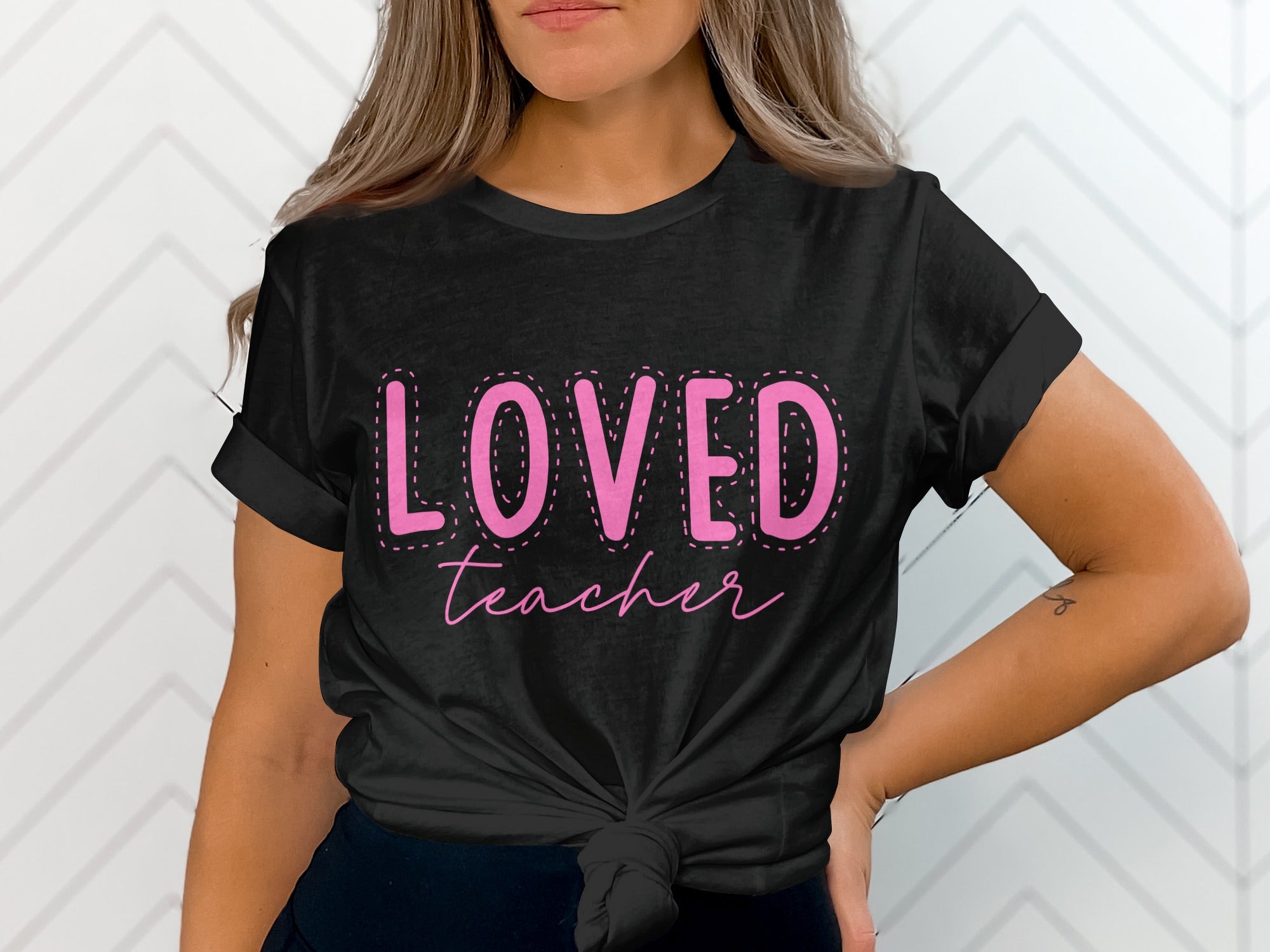 Black t-shirt with pink text "Loved Teacher" on the front.