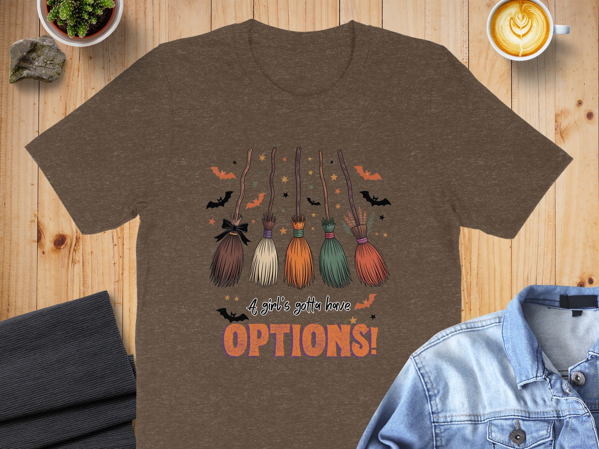 Brown t-shirt with brooms, bats, stars, and text "A girl's gotta have OPTIONS!".
