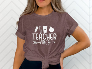 Brown t-shirt with white "Teacher Vibes" text and school icons.