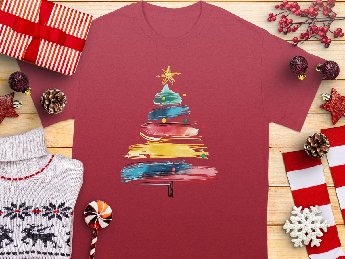 Maroon t-shirt with colorful abstract Christmas tree graphic and festive decorations.