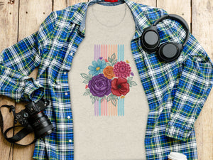 Light gray t-shirt with floral bouquet and colorful stripes graphic, spread open over a wooden surface.