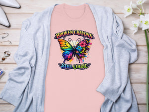 Pink t-shirt with a colorful butterfly graphic and text "BROKEN CRAYONS STILL COLOR".