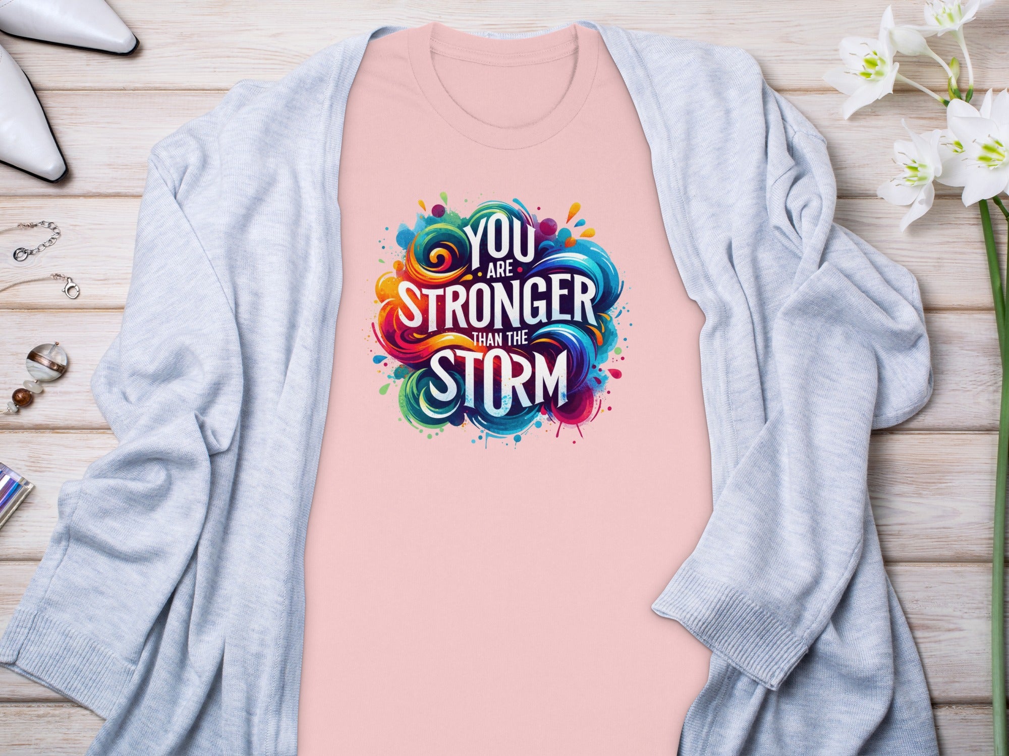 Pink t-shirt with "You are stronger than the storm" graphic