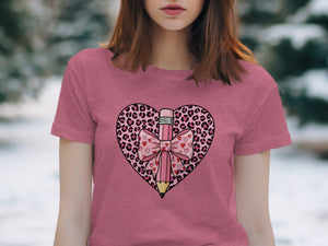 Pink t-shirt with a pink pencil and bow inside a leopard print heart graphic.